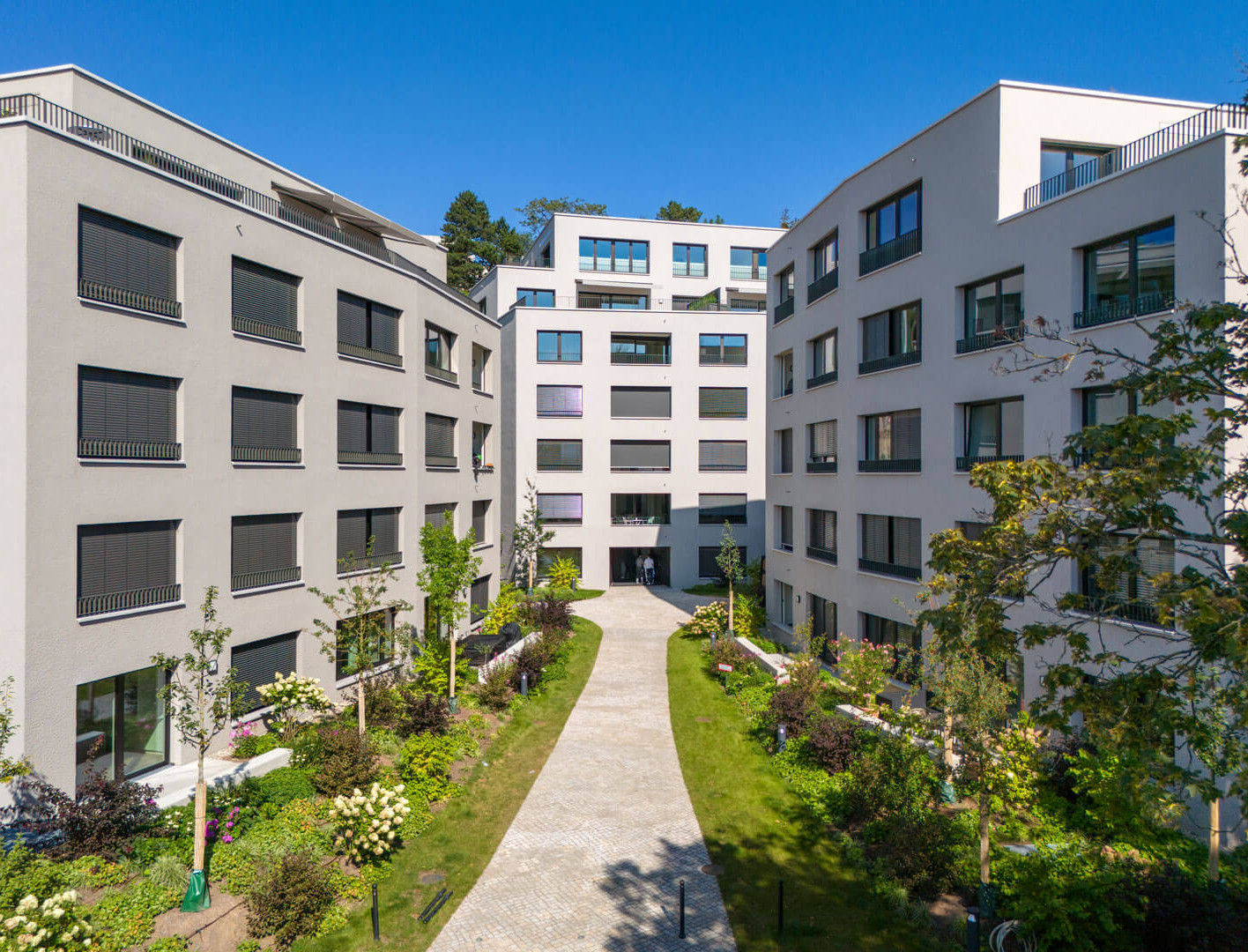 Wohnensemble an der Stafflenbergstraße, Stuttgart: polygonale Gebäude mit differenzierten Grautönen und facettierten Fassaden.