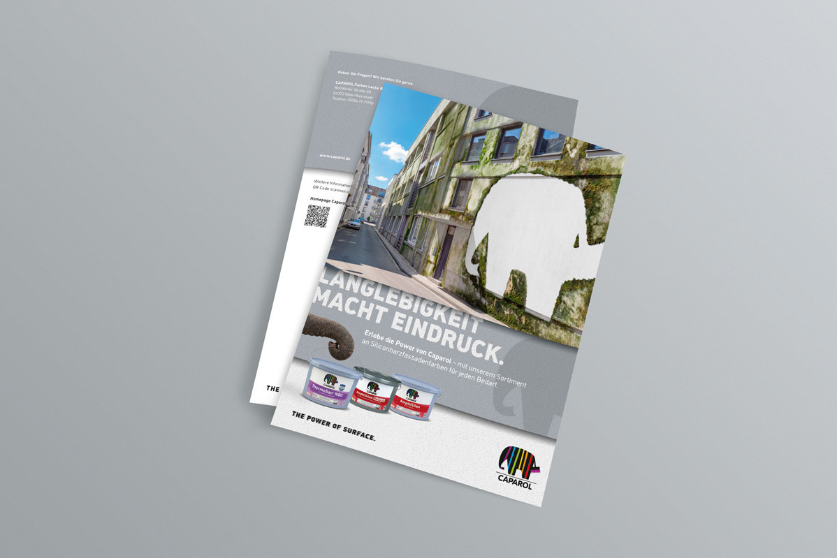 Zwei übereinanderliegende Werbeflyer mit einem Bild einer mit Moos bewachsenen Fassade und einem weißen Elefanten-Silhouettenausschnitt auf dem vorderen Flyer