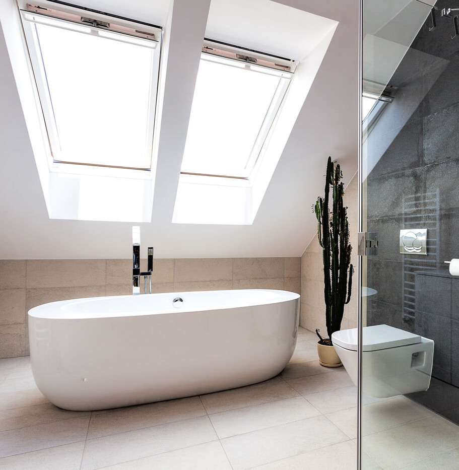 Modernes Badezimmer mit Glasdusche, großem Dachfenster, freistehender Badewanne und dunklen Wandfliesen.