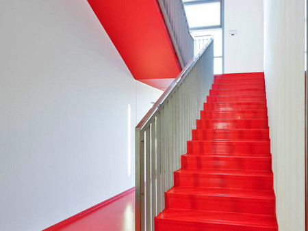 Die Firmenfarbe zieht sich wie ein „roter Faden“ durchs Treppenhaus: RAL 3020