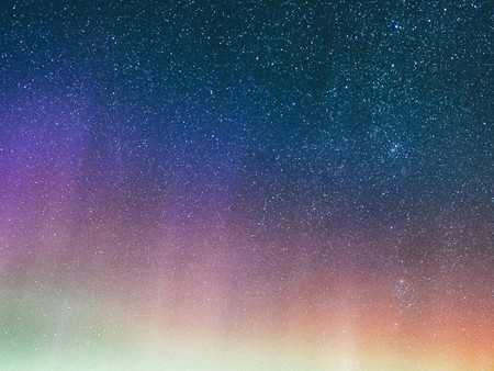 Ein sternenklarer, funkelnder Nachthimmel mit farbenfrohen Polarlichtern in sämtlichen Farben