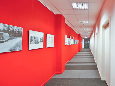 Farbe schafft Orientierung: Das Jedele-Rot (RAL 3020) führt Besucher durch das Treppenhaus bis zu den Seminarräumen.
Dabei wird der Weg zur Galerie - Fotografien dokumentieren Meilensteine aus mehr als 100 Jahren Firmengeschichte des Farbengroßhandels.