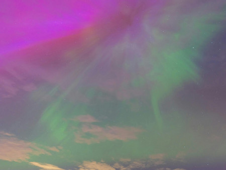 Bunter Dämmerungshimmel mit leuchtenden pinken und grünen, auroraähnlichen Lichtern