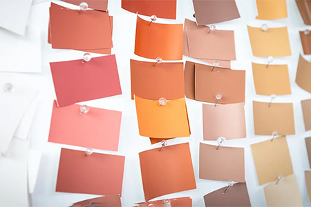 kleine Farbtafeln auf Pinnwand in orange gelb und brauntönen