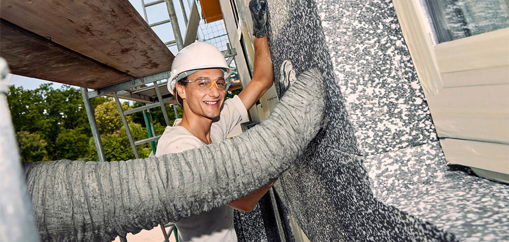 Handwerker vor Fassadendämmung, Elefantenrüssel im Bild