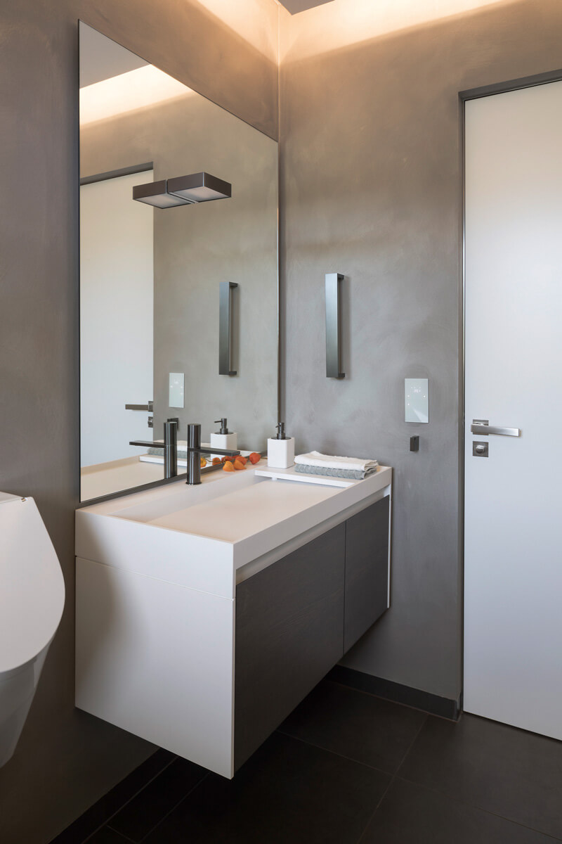 Waschbecken mit großem Spiegel an Wand in Betonoptik