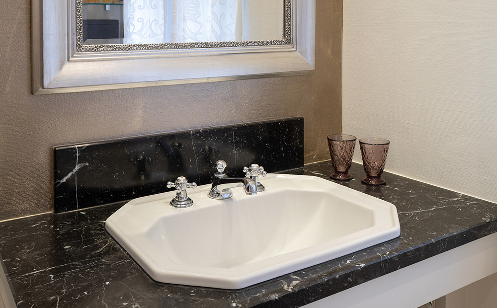 Im Spiegelbereich des Bades ist mit einer metallisch glänzenden Gestaltungstechnik eine edle Akzentfläche mit Capadecor Metallocryl Interior gesetzt (3D Marill 50 MET).