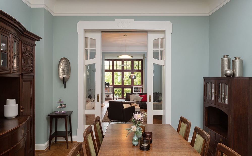 Die Wände in frischem Mint-Bleu (3D Patina 15) harmonieren mit den verschiedenen Holzoberflächen und betonen gleichzeitig die weißen Zierelemente im Raum. Es entsteht ein leichtes, luftiges, elegantes Ambiente.