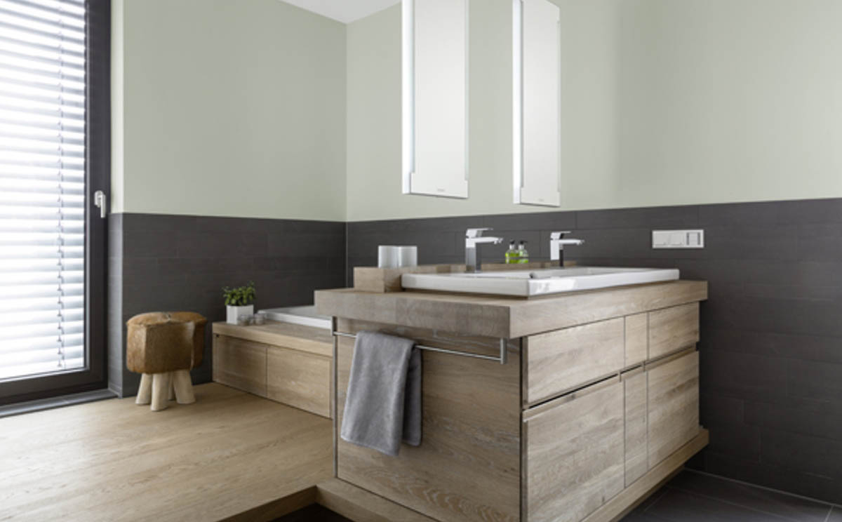 Das Bad wirkt natürlich, besonders durch die Materialien Holz, Steinfliesen und Leder. Das frische, kühle Grün der Wände (3D Malachit 25) unterstreicht diesen Eindruck.