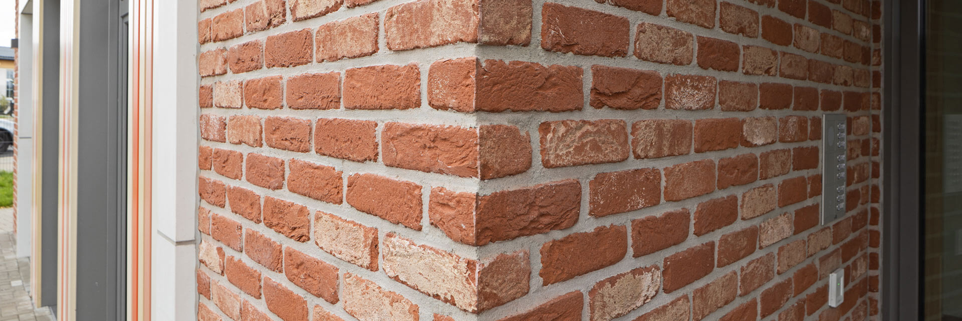 Nahaufnahme der WDVS-Fassade des Kindergartenneubaus in Ralbitz-Rosenthal mit Klinker, Faserbeton und modernen Fenstern.