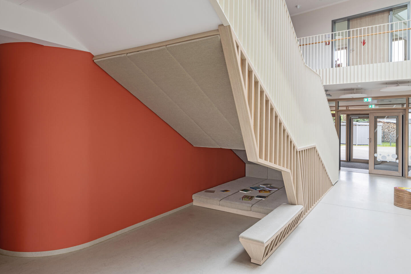 Rückseite des Treppenaufgangs im Neubau der Kindertagesstätte Ralbitz-Rosenthal vor lachsfarbener Wand und Fensterfront.