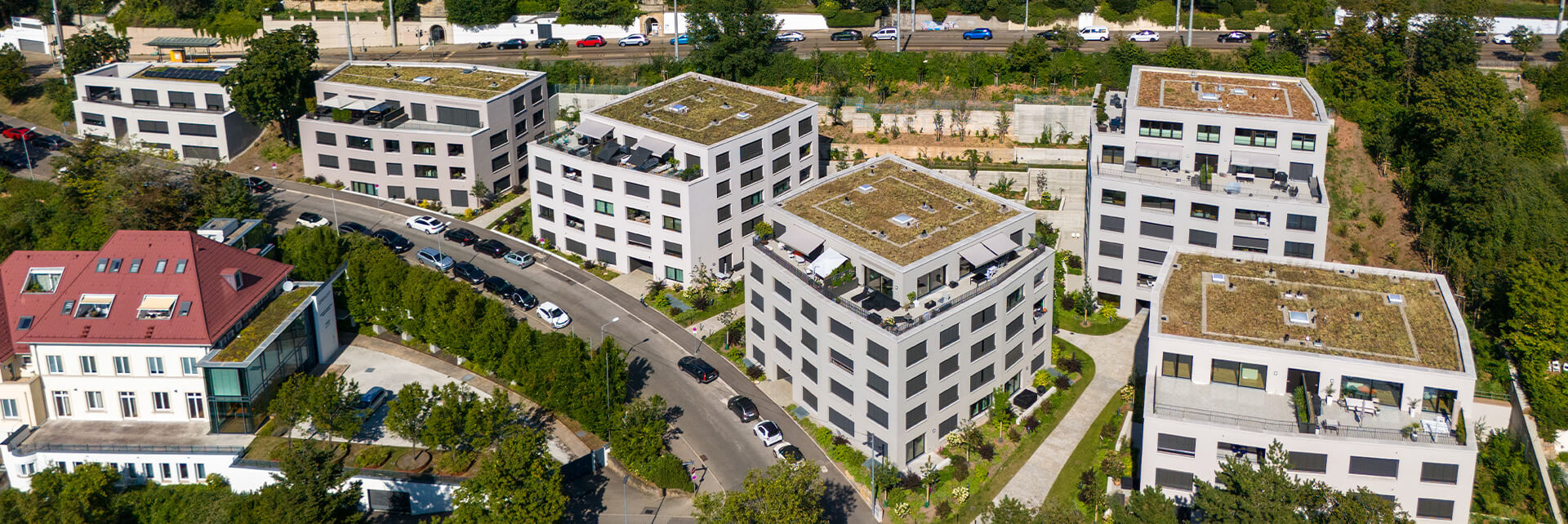 Blick von oben auf das polygonale Wohnensemble in erdigen Grautönen, Stafflenbergstraße, Stuttgart, eingebettet ins Grüne.