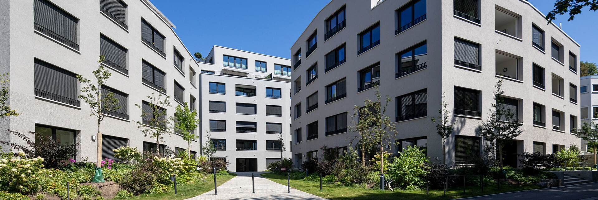 Wohnensemble an der Stafflenbergstraße, Stuttgart: polygonale Gebäude mit differenzierten Grautönen und facettierten Fassaden.