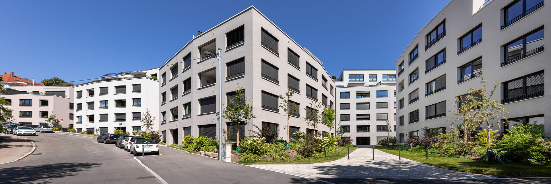Wohnensemble an der Stafflenbergstraße, Stuttgart: polygonale Gebäude mit differenzierten Grautönen und facettierten Fassaden.