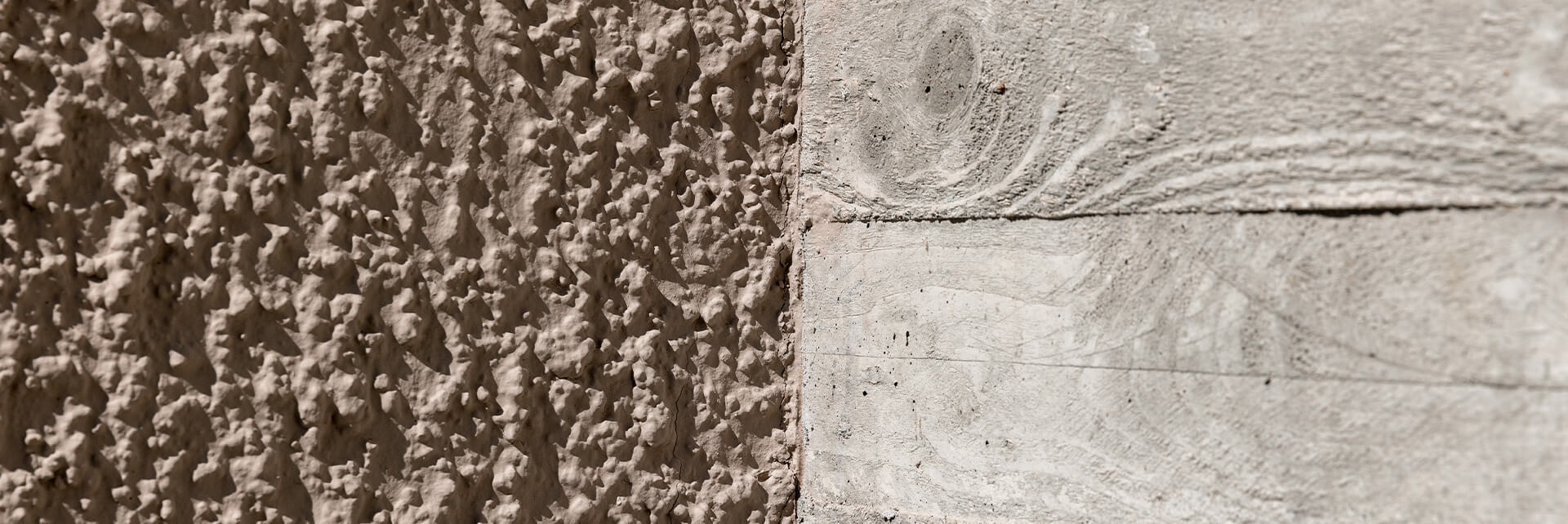 Nahaufnahme der facettierten Außenwand eines polygonalen Wohngebäudes in erdigen Grautönen, Stafflenbergstraße, Stuttgart.