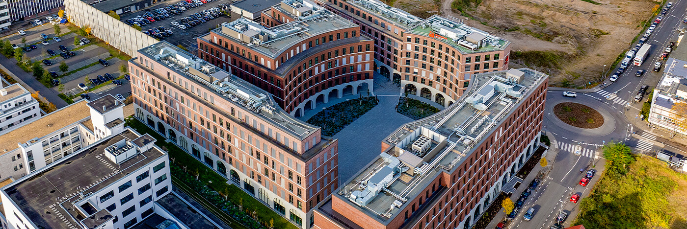 Luftaufnahme des Quartiers Ovum mit vier Baukörpern und zentralem Platzbereich