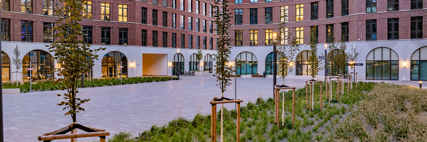 Großzügiger Innenhof des Ovum-Quartiers mit teilbegrünter Freifläche und moderner Architektur